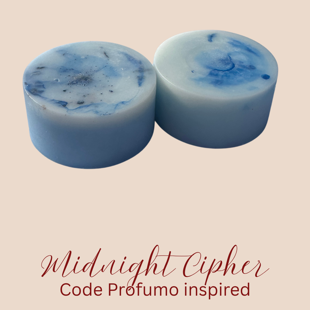 Two cylindrical blue and white marbled wax melts on a beige background with the text 'Midnight Cipher Code Profumo inspired' below.